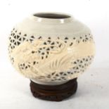 A Chinese ceramic pierced bowl, with dragon decoration, on carved wood stand, height 27cm overall