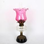 An Antique oil lamp with cut-glass font and cranberry glass shade, height 55cm