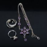 A silver and amethyst set star design drop pendant necklace, with matching ring, and a silver puzzle
