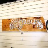 A painted and gilded wood sign "The Old Stables", length 123cm