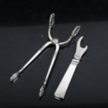 GEORG JENSEN - a silver bottle opener (boxed), and COHR - a pair of stylised silver tongs