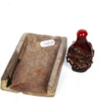 A Chinese slate ink stone, and a small red amber snuff bottle (2)