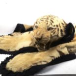 TAXIDERMY - a tiger skin rug, early 20th century, modelled with head baring teeth, on a felt backing
