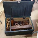 A steel-bound tool chest, containing various woodworking planes and chisels