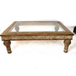 An American rectangular coffee table with central glass top, carved frieze, on turned legs,