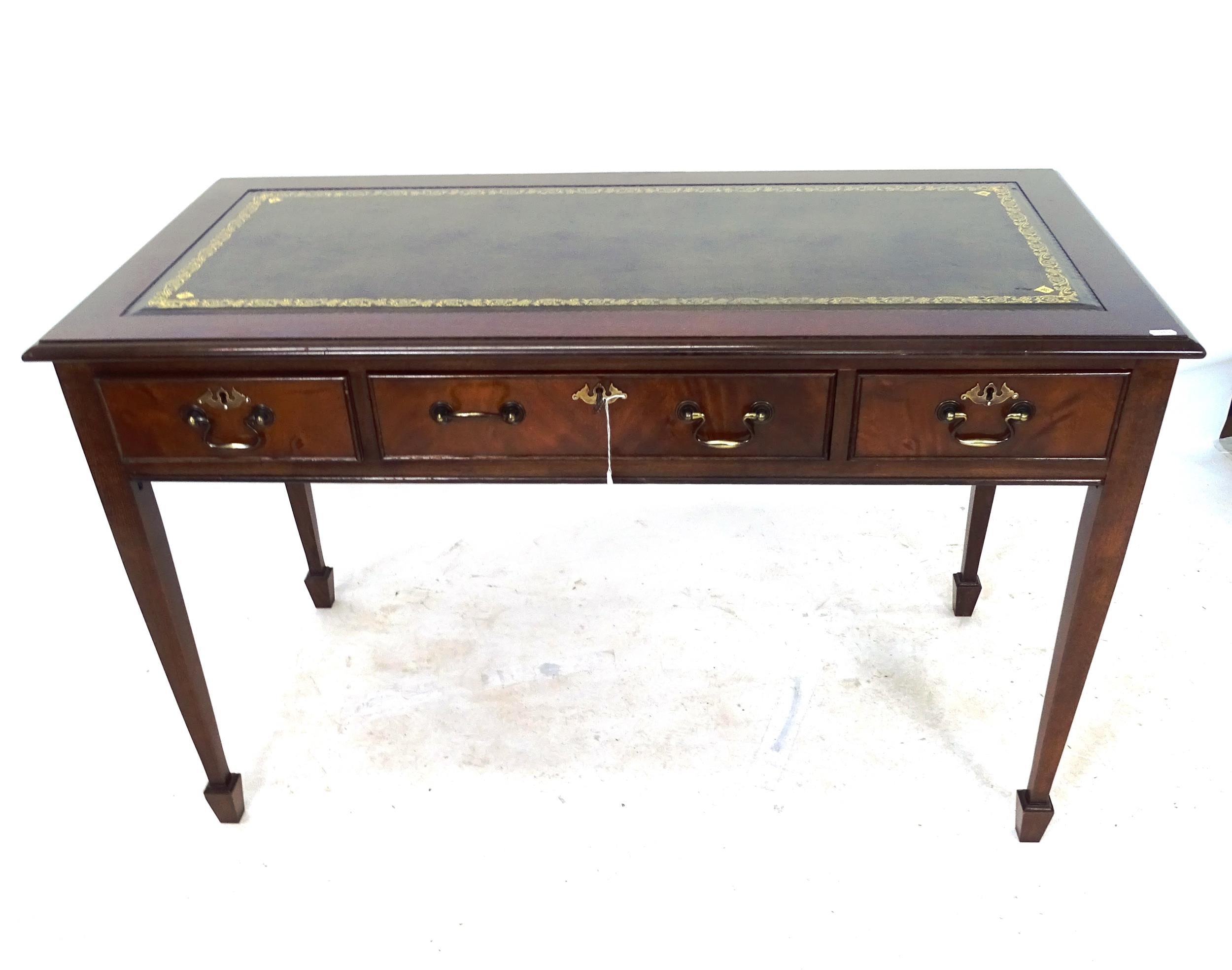 A reproduction mahogany writing table, with an inset green leather skiver, 3 frieze drawers, on