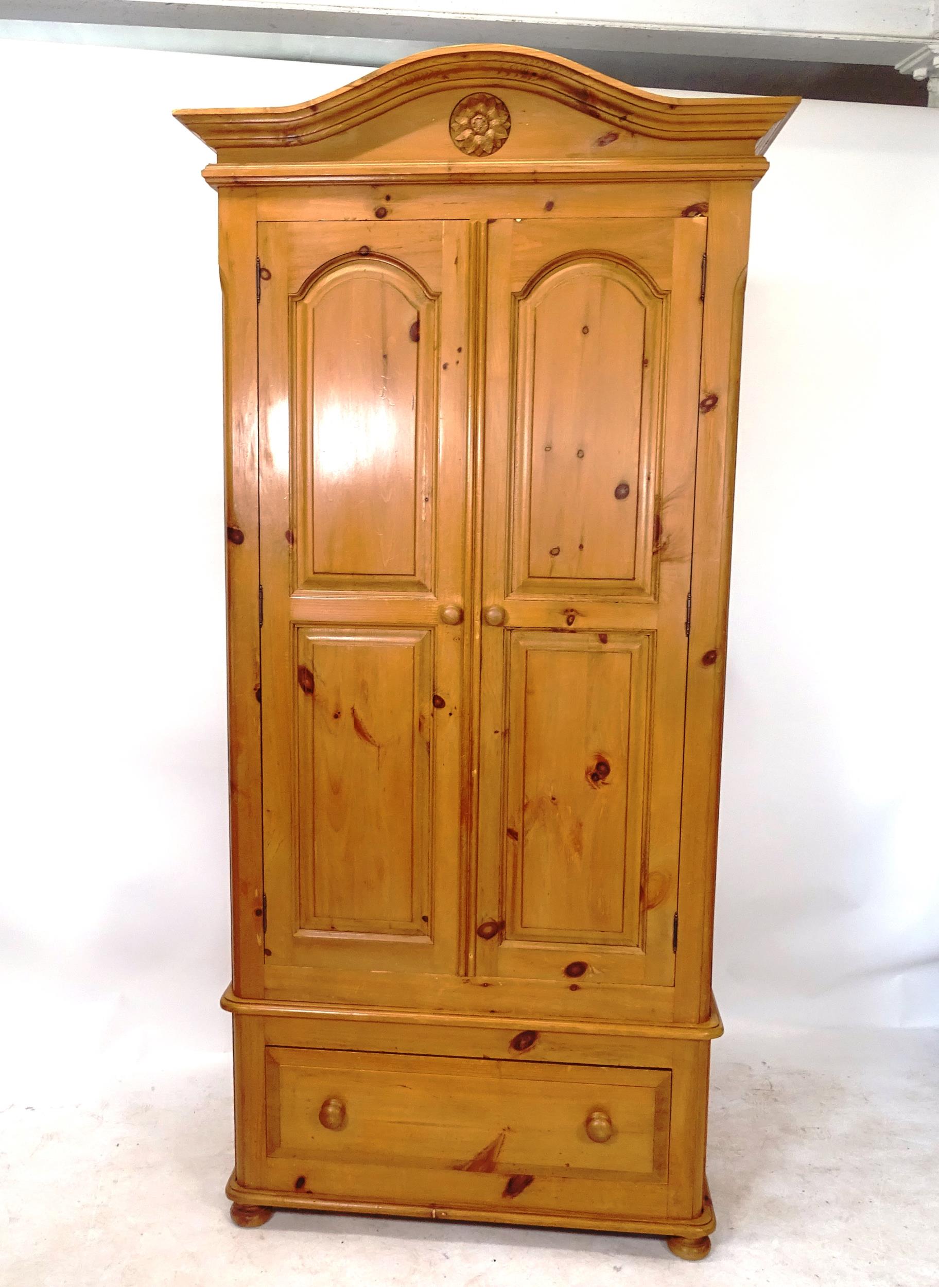 A polished pine 2-door wardrobe with drawer fitted base, W102cm, H215cm, D62cm