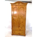 A polished pine 2-door wardrobe with drawer fitted base, W102cm, H215cm, D62cm