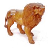 A carved hardwood study of a lion, length 90cm, H77cm