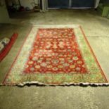 A red and green ground Persian design carpet, with floral symmetrical pattern, 423cm x 290cm (