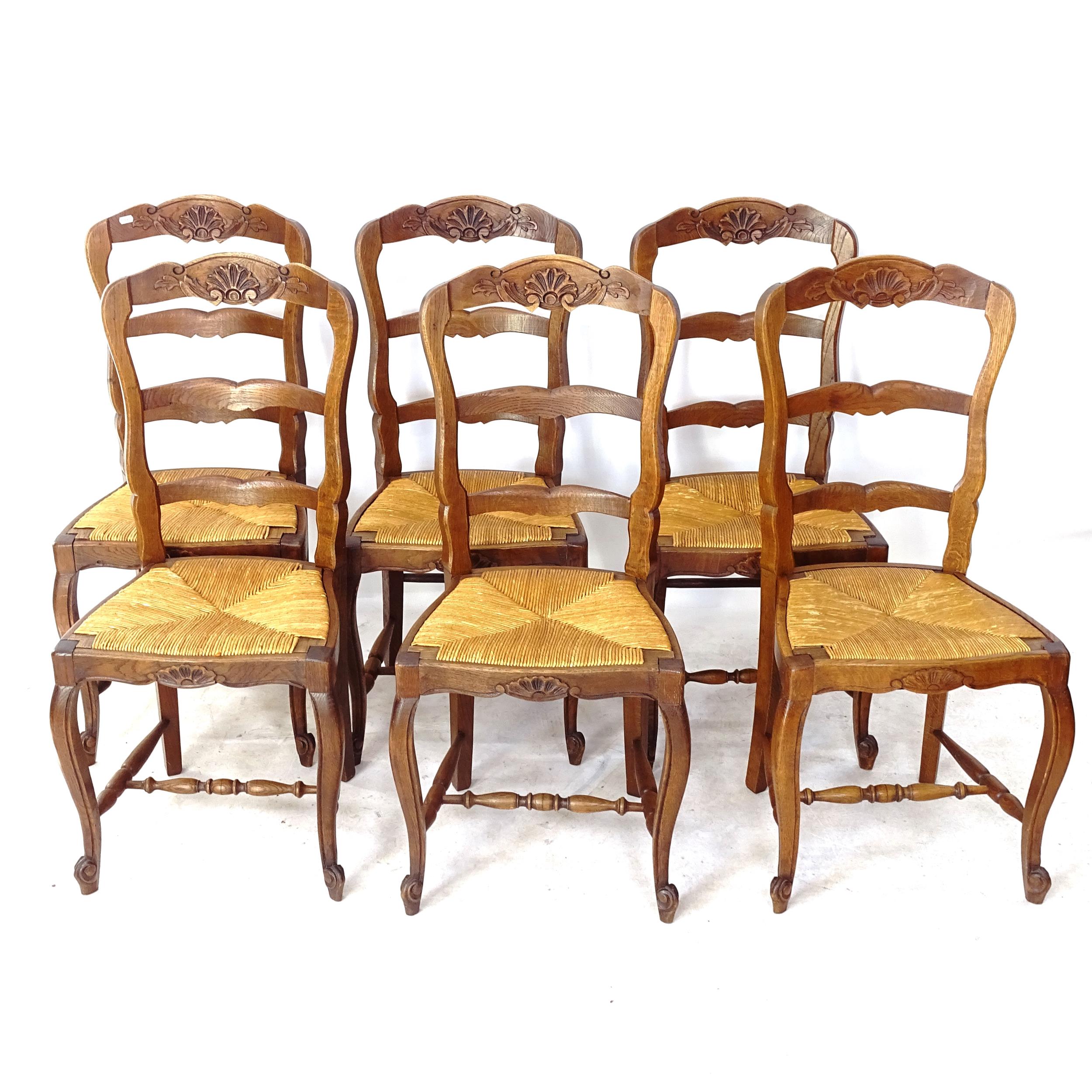 A set of 6 French carved oak ladder-back rush-seated dining chairs