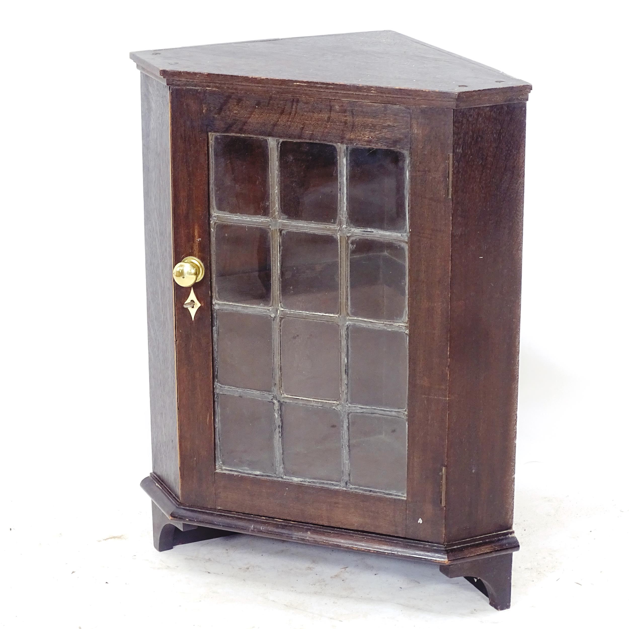 An Antique stained pine hanging corner cabinet, with single glass panelled door, W51cm, H66cm, D32cm