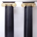 A pair of fibreglass Ionic columns painted in black and gold, H229cm