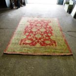 A red and green ground Persian design carpet, 352cm x 268cm (viewing by appointment only as this