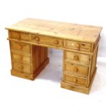 A polished pine pedestal desk with 9 drawers, W121cm, H77cm, D60cm
