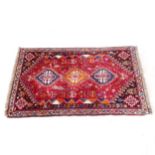 A red ground Persian design rug, 176cm x 107cm