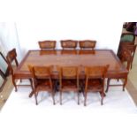 An Indian hardwood dining room table and 8 chairs, the table having floral carved edge with brass