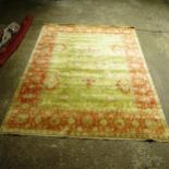 A large green ground Persian design carpet, with red border, 350cm x 270cm (Viewing by appointment