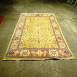 A large Persian design carpet, with a green and blue border and symmetrical floral lozenge, on a