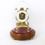 A reproduction brass skeleton clock under glass dome, overall height 36cm, with pendulum and key