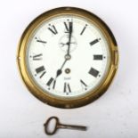 A brass ship's bulkhead clock, by Sestrel, dial diameter 15.5cm, working order, with key