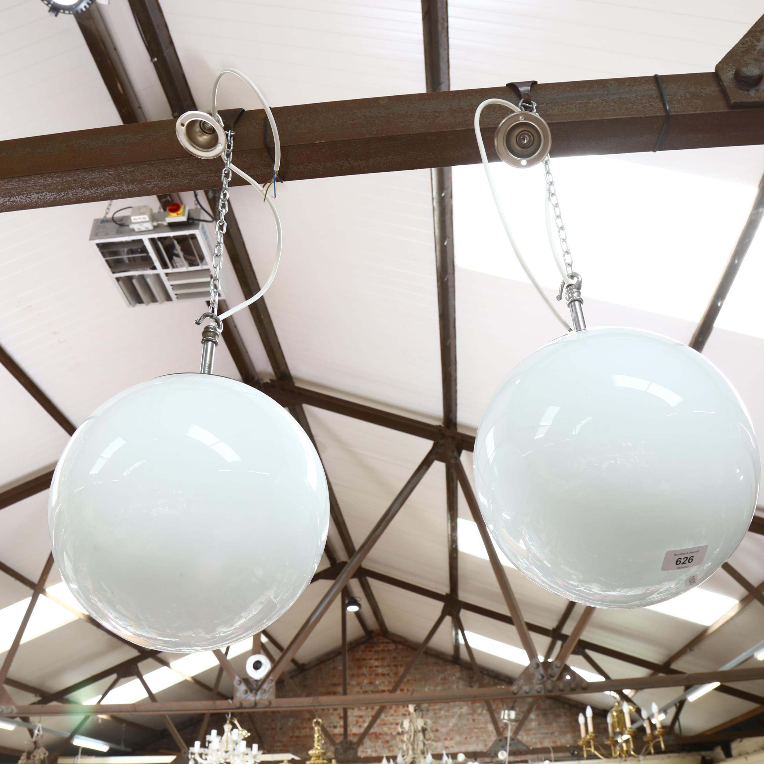 A pair of milk glass globular pendant light fittings, diameter 22cm