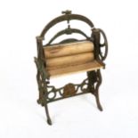 A miniature cast-iron mangle with wooden rollers, height 27cm