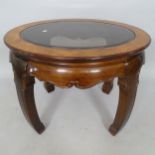 An Oriental style hardwood oval occasional table, with inset glass top, 69cm x 54cm x 60cm