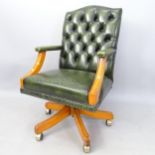 A green studded leather upholstered swivel desk chair