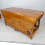 A contemporary yew wood drop leaf dining table, 149.86cm x 73.66cm x 70cm
