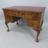 A 1930s walnut kneehole writing desk, with 4 fitted drawers, on cabriole legs with claw and ball