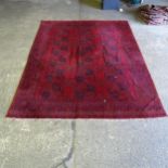 A large red ground Afghan carpet, 331cm x 260cm (Viewing by appointment only for this Lot as it is