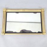 A Regency gilt oval mantel mirror, with ebonised mounts and split turned columns, 90cm x 57cm