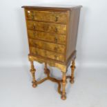 A reproduction burr-walnut and ebony-strung 1-section chest on stand/music cabinet, having 5 fall-