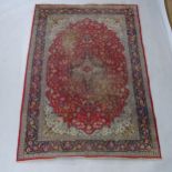 A red ground Shiraz design rug, with symmetrical border, 185cm x 126cm Rug is quite heavily worn