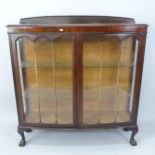 A 1930s mahogany bow-front display cabinet, with 2 glazed doors, and 2 fixed shelves, 120cm x