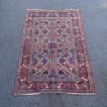 An Antique red ground Persian Isfahan rug, with repeating border and floral decorated square