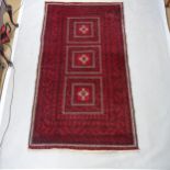 A red ground Baluchi rug, 215cm x 118cm