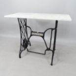 A rectangular white and grey veined marble-top garden table, on a wrought-iron Singer sewing machine