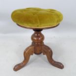 A Victorian walnut revolving piano stool