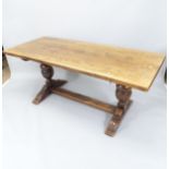 An Antique oak-topped refectory dining table, with baluster turned legs and H-shaped stretcher,
