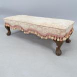 A 1920s upholstered fender stool, on acanthus leaf carved cabriole legs, 95cm x 30cm x 38cm