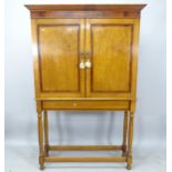 A 19th century oak and mahogany-banded cupboard on stand, with the 2 panelled doors revealing