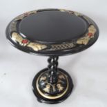 A circular-topped black lacquered occasional table, on spiral turned column with carved