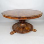 A 19th century rosewood tilt-top table, with circular base and lion paw feet, 130cm x 71cm
