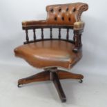 A studded and button-back brown leather bow-arm swivel office chair