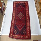 A red ground Persian rug, 265cm x 113cm