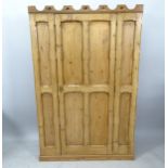 An Antique Gothic style polished pine cabinet, with castellated design top, single panelled door,