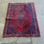 A red ground Iranian rug, 203cm x 154cm (Viewing by appointment only for this Lot as it is not on