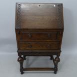 A small carved oak 2-drawer bureau, 65cm x 105cm x 40cm